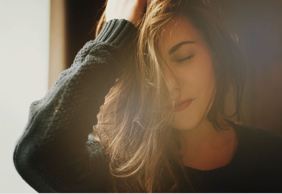 Woman applying Argan Oil to her hair - A natural elixir hailed for combating hair loss and promoting thicker, healthier strands.