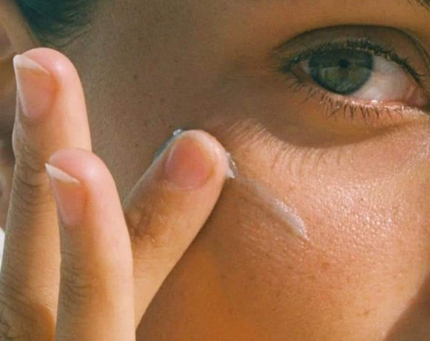 A close-up of a person gently applying our revitalizing eye serum with vitamin C for a rejuvenated and youthful appearance