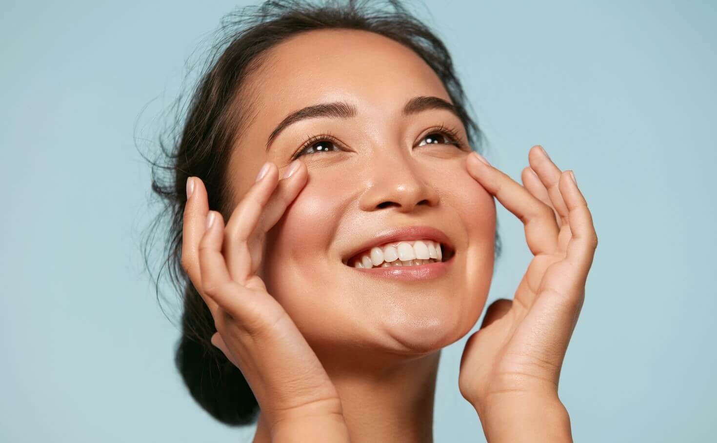A woman applying natural skincare products to reduce dullness on her face