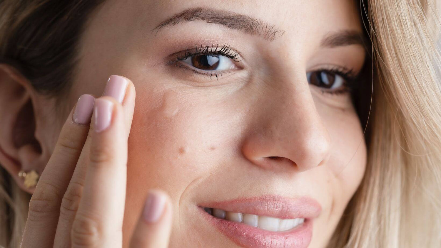 A woman applying our revitalizing eye serum on her eye to reduce dark circles